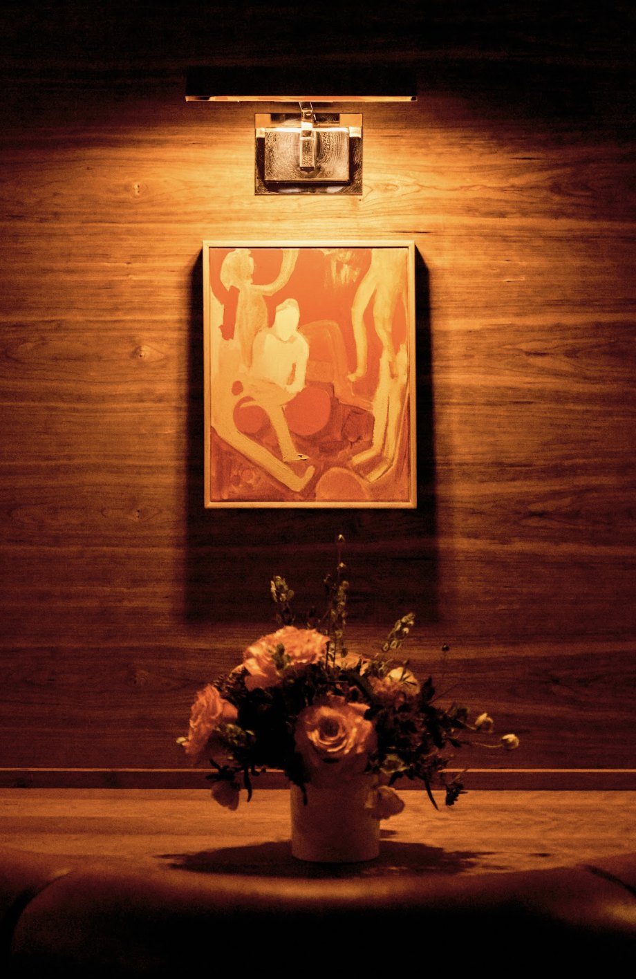 Artwork and flowers on the wood wall
